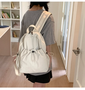 Detailed back view of a white drawstring backpack showing capacity and side bottle pocket