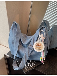 Large blue denim crossbody bag with adjustable strap and cute capybara charm