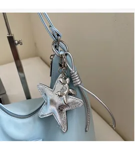 Detail of light blue bag featuring a metallic silver star and balloon dog charm