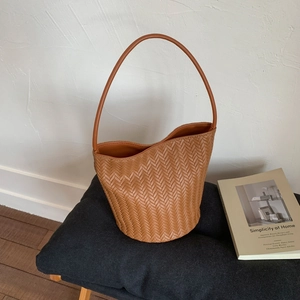 French vintage brown woven bucket bag with elegant shoulder strap and retro texture