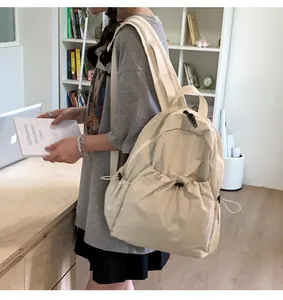 Detail of cream pleated drawstring backpack with wide shoulder straps in casual style
