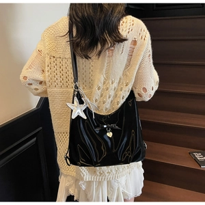 Glossy black hobo shoulder bag featuring a decorative bow and metallic star pendant