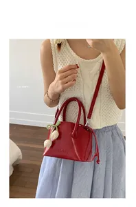 Detail of red patent leather bucket bag with London embossing and a tulip charm pendant