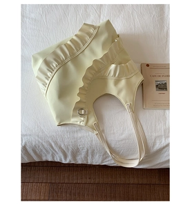 Detail of cream yellow shoulder bag featuring elegant ruffled edges and nylon texture