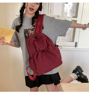 Deep red drawstring backpack for women in nylon with side pockets and buckles