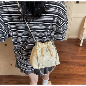 Détail du sac seau matelassé crème avec strass en étoile et bandoulière chaîne