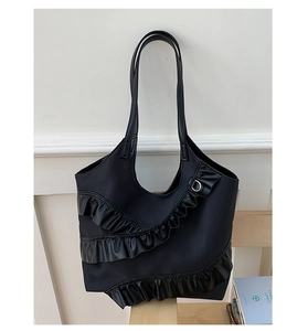 Detail of black tote bag with three-tier pleated ruffles and slender shoulder straps