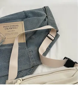 Détail de la bandoulière réglable en tissu beige avec boucle sur le sac blanc