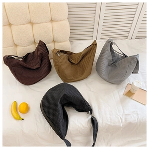 Nylon Umhängetaschen in Kaffee, Khaki, Grau und Schwarz auf einem Bett präsentiert