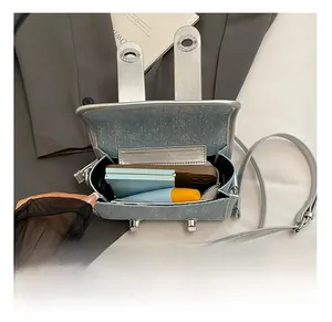 Vue intérieure du sac bandoulière bleu clair montrant l'espace pour téléphone et cosmétiques