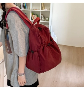 Detail of burgundy drawstring backpack made of water-repellent nylon material