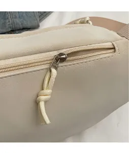 Détail du sac bandoulière crème avec fermeture éclair et tirette en corde tressée