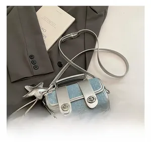 Détail du sac bandoulière en denim bleu clair avec garniture argentée et étoile