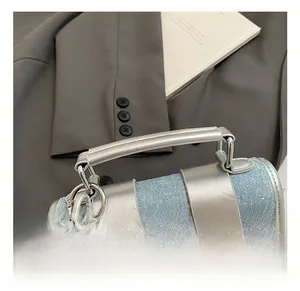 Détail du sac polochon en denim bleu avec breloques étoiles et pendentif chien ballon