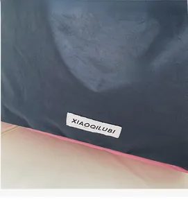 Detail der marineblauen Nylon-Beuteltasche mit rosa Akzent und weißem Label