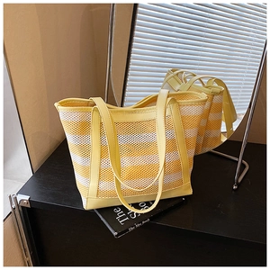 Detailed macro view of yellow and white striped mesh tote with premium leather trim
