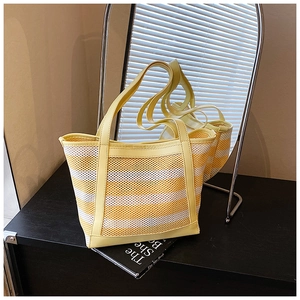 Close-up of a striped mesh tote bag with yellow leather trim for summer beach outings