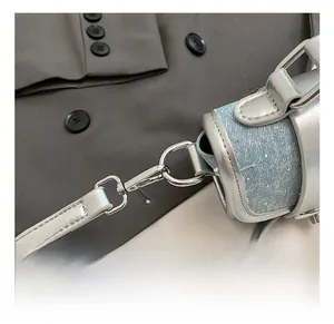 Gros plan sur un sac en denim bleu pailleté avec des crochets métalliques argentés