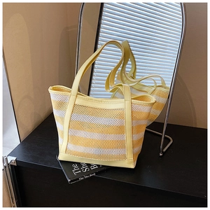 Macro detail of breathable yellow and white striped mesh tote bag with faux leather handles