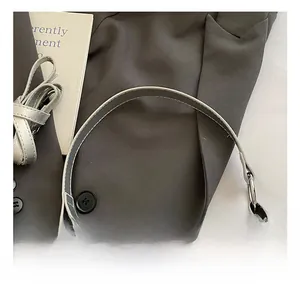 Dettaglio del manico in pelle argento con cuciture e anello di fissaggio metallo