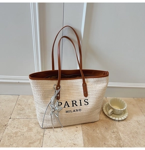 Detailed macro view of woven straw texture with PARIS MILANO embroidery and star charm
