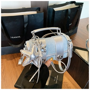 Détail du sac cylindre argenté pailleté avec charms étoile et chien ballon