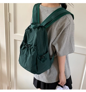 Dark green nylon drawstring backpack for women shown on a model for daily casual wear