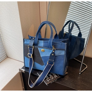 Detail der Denim-Einkaufstasche im Color-Block-Design mit goldener Schließe und Gurt