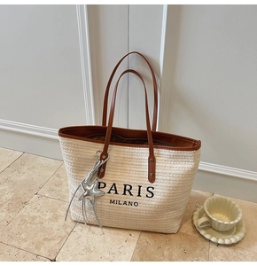 Detail of rainbow woven tote bag with Paris Milano print and star pendant accessory