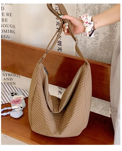 Detail einer braun karierten Hobo-Tasche aus Nylon mit breitem Gurt und Reißverschluss