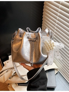 Silver metallic leather bucket bag with chain drawstring and pearl heart charm accessory