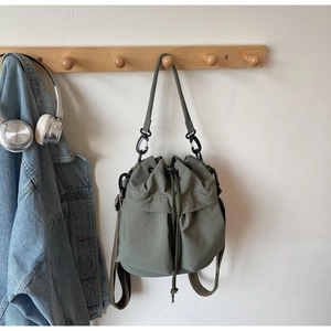 Detail of army green nylon bucket bag with climbing buckle and adjustable strap