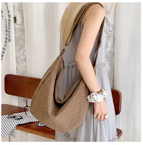 Detailansicht einer großen braun karierten Hobo-Tasche aus Nylon am Model
