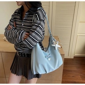 Detail of light blue nylon hobo bag with heart pendant and silver star charm detail