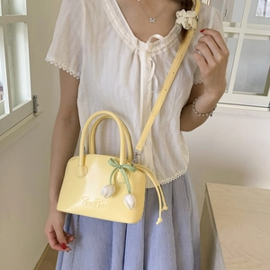 Detail of yellow PU leather bucket bag with TonTon embossing and tulip flower charm