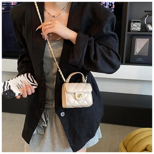 Quilted beige mini crossbody bag with gold chain strap shown on model in modern interior
