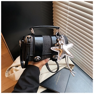 Détail d'un sac à main en denim bleu foncé avec étoiles pailletées et chien ballon