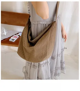 Braune karierte Nylon-Hobo-Tasche von der Seite an einem Modell für den Alltag