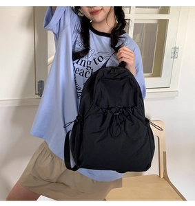 Detail of black drawstring backpack showing adjustable buckle and lightweight nylon texture