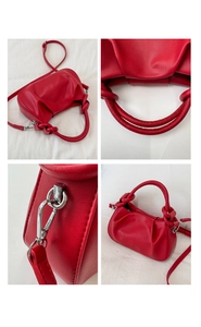 Detail view of red cloud-shaped PU bag with knotted handle and silver metal hardware