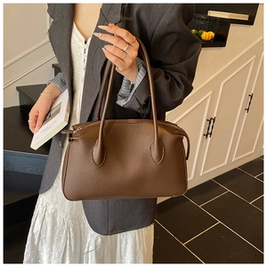 Dettaglio borsa tote in pelle marrone scuro con cerniera e doppi manici lunghi ed eleganti