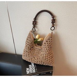 Detailed close-up of woven hollow texture and distinctive wooden bead handle on handbag