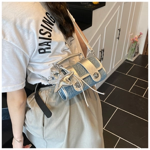 Détail d'un sac bandoulière en denim avec garniture argentée et pendentif étoile