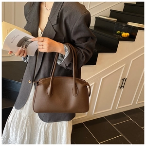 Elegante borsa tote in pelle marrone scuro con trama a litchi tenuta da modella