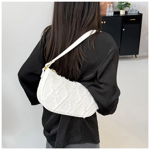 Detail view of white denim half-moon underarm bag with quilted texture and frayed edges