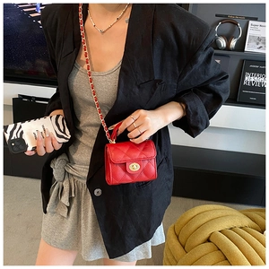 Classic red quilted crossbody bag with gold twist lock and chain strap on female model