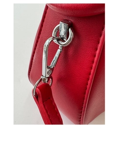 Macro detail of silver metal hooks and high-quality stitching on a red ruched cloud bag