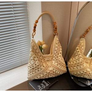 Detail of hand-woven crochet hobo bag featuring natural wooden bead handles and hollow texture