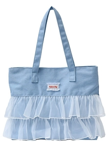 Light blue canvas tote bag with white tulle ruffle trim and fashion tag on white background