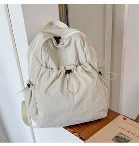 Detailed view of beige drawstring backpack with side pockets and large capacity storage
